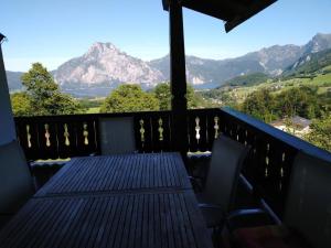 a balcony with a table and chairs and mountains at Gemütliches Landhaus in Panorama-Lage mit herrlichem See- und Bergblick in Vichtau