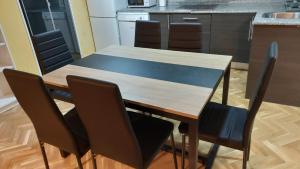 cocina con mesa de madera y sillas en Apartamentos Sol Mayor, en Madrid