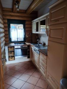 a kitchen with white cabinets and a sink and a stove at Blockbohlenhaus in Wackersdorf