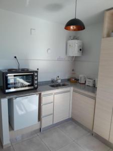 een keuken met een magnetron en een wastafel bij URBANO Dpto in Villa María