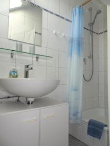 biała łazienka z umywalką i prysznicem w obiekcie Haus Holzheimer mit dem einzigartigen Blick auf Bad Kissingen und die Rhön - b43286 w mieście Bad Kissingen