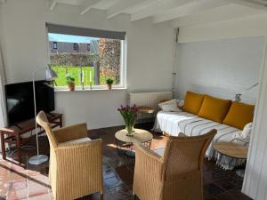 un salon avec un canapé, une table et des chaises dans l'établissement Vakantiehuis Buitenplaats Schouwen, à Burgh-Haamstede