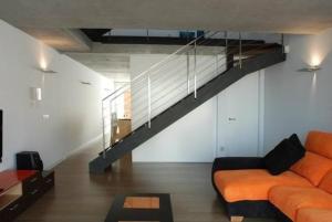un soggiorno con divano arancione e scala di Appartement in Son Baulo mit Terrasse a Can Picafort
