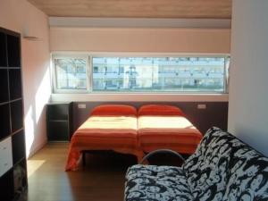una camera con letto, divano e finestra di Appartement in Son Baulo mit Terrasse a Can Picafort