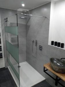a bathroom with a glass shower with a sink at Blockbohlenhaus in Wackersdorf
