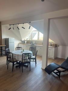 a kitchen and dining room with a table and chairs at Hotello Apartmanház és Panzió in Zalaegerszeg