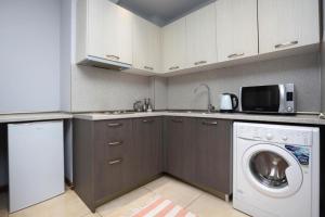 a kitchen with a washing machine and a microwave at Apartment near Republic Square in Yerevan