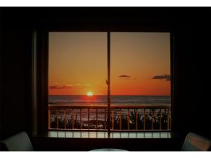 uma janela com vista para a praia ao pôr-do-sol em Taiheian - Vacation STAY 57439v em Sakai