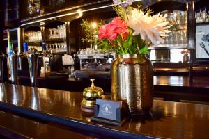 un jarrón de flores sentado en un mostrador en un bar en Hotel Restaurant 't Ronde Loegh, en Winschoten