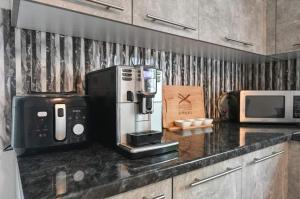a kitchen counter with a coffee maker and a microwave at Villa maskara in Bihać
