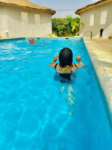 a person swimming in a swimming pool at Melia's hotel in Sali Nianiaral