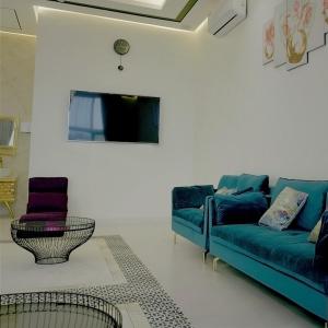 uma sala de estar com um sofá azul e duas cadeiras em Lura Chalet em Barka