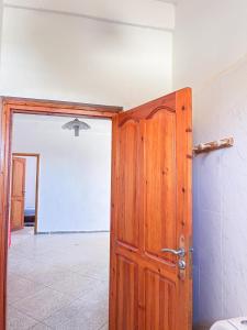 an open wooden door in a room with a tile floor at Oceana surf house in Imsouane