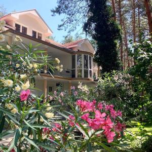 una casa rosa con flores delante en Vila Dunavski Raj, en Golubac