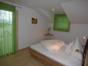 Schlafzimmer mit einem weißen Bett und grünen Vorhängen in der Unterkunft Appartement in Altenburg mit Terrasse und wunderbarem Ausblick in die Südtiroler Bergwelt in Castelvecchio