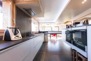 a kitchen with white cabinets and a black counter top at K'banalours in Sallanches