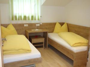 2 Betten mit gelben Kissen in einem Zimmer in der Unterkunft Appartement in Altenburg mit Terrasse und wunderbarem Ausblick in die Südtiroler Bergwelt in Castelvecchio