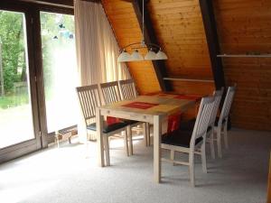 - une table et des chaises en bois dans une chambre avec fenêtre dans l'établissement Ferienhaus in Machtlos mit Terrasse und gemeinschaftlichem Pool, à Ronshausen