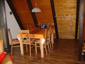 - une salle à manger avec une table et des chaises en bois dans l'établissement Ferienhaus in Machtlos mit Terrasse und gemeinschaftlichem Pool, à Ronshausen