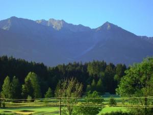 - une vue sur un parcours de golf avec des montagnes en arrière-plan dans l'établissement Einmalige Panorama-Bergsicht in die Allgäuer Alpen in ruhiger Einzellage, à Ofterschwang