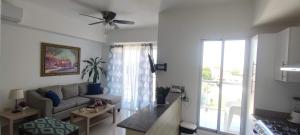 sala de estar con sofá y ventana en Boca del Mar Residence, Boca Chica en Boca Chica