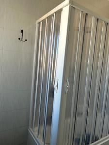 La salle de bains est pourvue d'une douche avec une porte en verre. dans l'établissement Solymar House Lacco Ameno, à Ischia