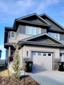 a house with a garage and a driveway at Sunny Perch Stay in Edmonton