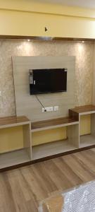 a entertainment center with a television on a wall at Hotel Reliance in kolkata