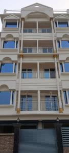 wysoki biały budynek z mnóstwem okien w obiekcie Hotel Reliance w mieście kolkata