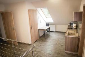 Il comprend une petite cuisine avec un évier, une table et une fenêtre. dans l'établissement Wohnung in Zieleniewo mit Garten und Grill, à Zieleniewo