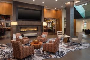 a lobby with a fireplace and chairs and a tv at The Hotel at Arundel Preserve in Hanover