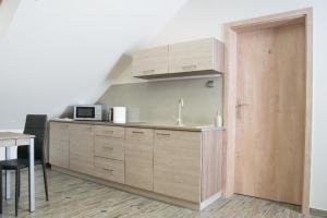 a kitchen with wooden cabinets and a sink and a table at Wohnung in Zieleniewo mit Garten und Grill in Zieleniewo