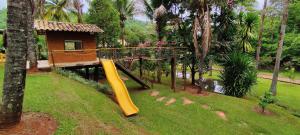 a playground in front of a house with a slide at Chacara com Wi-Fi e piscina em Ouro Verde De Goias in Matão