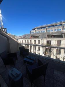 - un balcon avec des chaises et des tables en face d'un bâtiment dans l'établissement Magnificent apartment, Geneva Center, Geneva Lake, à Genève