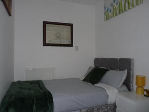 Schlafzimmer mit einem Bett und einem Wandspiegel in der Unterkunft Home Away in London