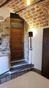 a room with a wooden door in a stone wall at A Burgâ du Muntin in Spotorno