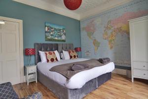 帕爾的住宿－Roselyn House，卧室配有一张大床,墙上挂有地图