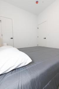 a white bedroom with a bed with four closets at Fully Furnished 2BR Gem mins to NYC in Bayonne