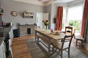 a kitchen and dining room with a wooden table at Roselyn House in Par