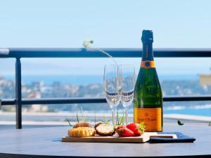 a bottle of wine and two glasses on a table at Penthouse over Monaco in Beausoleil