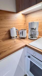 a kitchen with two toasters on a wooden counter top at Apartament PURPLE in Poznań