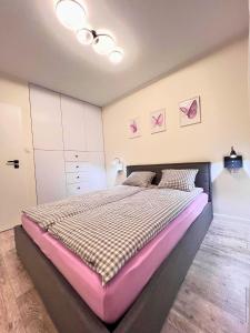 a bedroom with a large bed with a pink mattress at Apartament PURPLE in Poznań