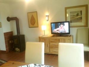 a living room with a tv on a wooden dresser at Ferienhaus in Zandt mit Kleiner Terrasse in Zandt