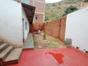 eine Gasse mit rotem Boden und Ziegelwand in der Unterkunft OCALA HOUSE 3.0 in Huánuco