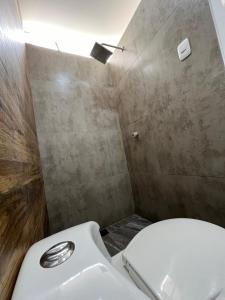 a bathroom with a white toilet and a shower at Casa sabina aeropuerto plus 1 in Lima