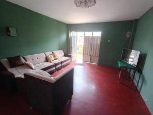 een woonkamer met een bank en een televisie bij OCALA HOUSE 3.0 in Huánuco