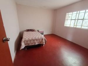 1 dormitorio con 1 cama en una habitación con ventana en OCALA HOUSE 3.0, en Huánuco