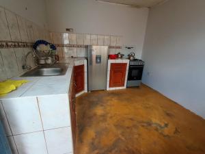 uma pequena cozinha com um lavatório e um fogão em OCALA HOUSE 3.0 em Huánuco