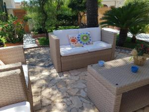 a patio with a couch and two chairs and a table at Lo Scalo 2.0 in Marina di Ragusa