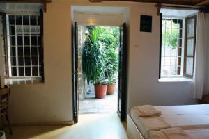 una camera da letto con porta che si apre su un patio con piante di Sotos pension a Skopelos Town